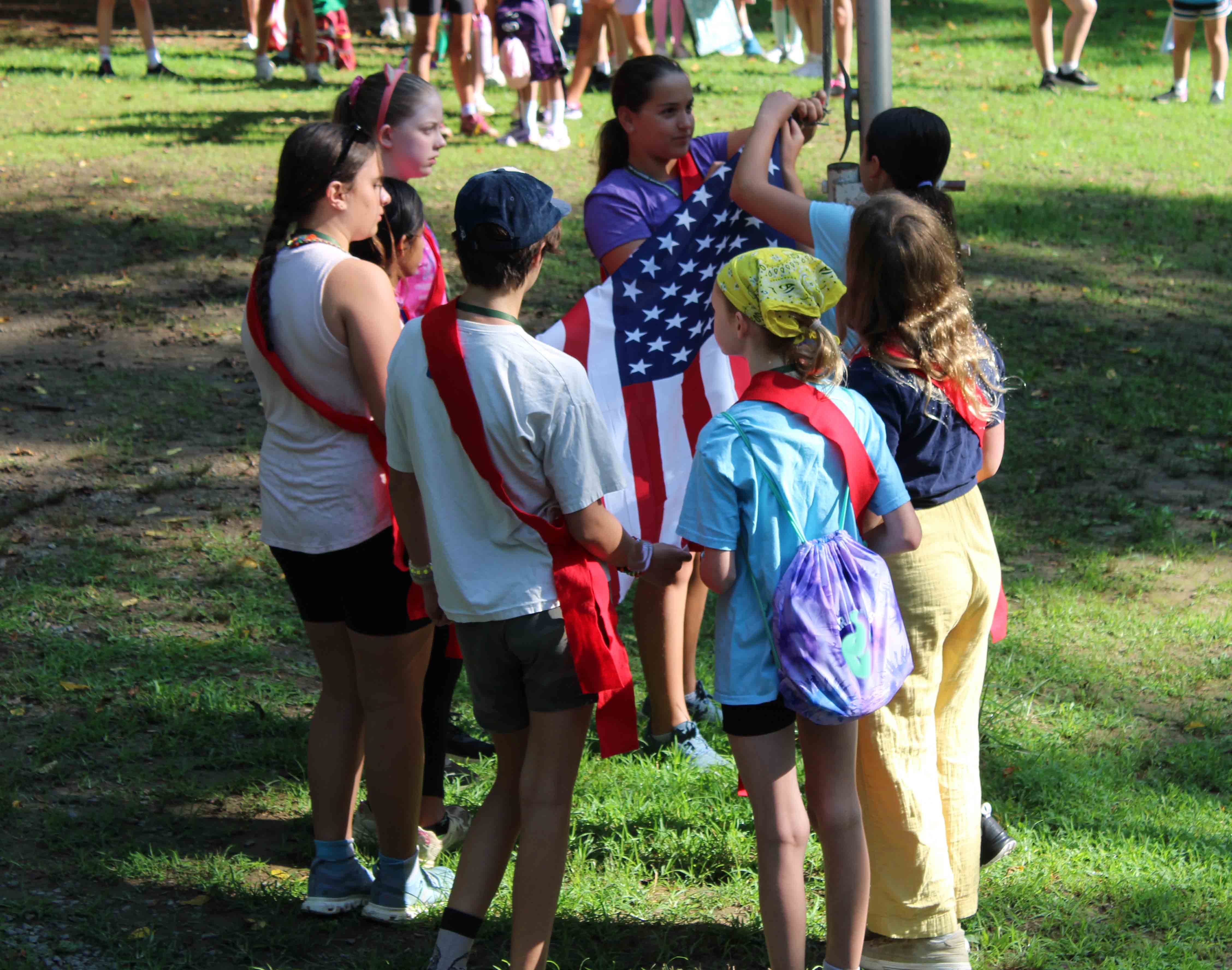 Campers from the Catapults unit gathered together on the grass to prepare and raise the American flag during the morning ceremony.