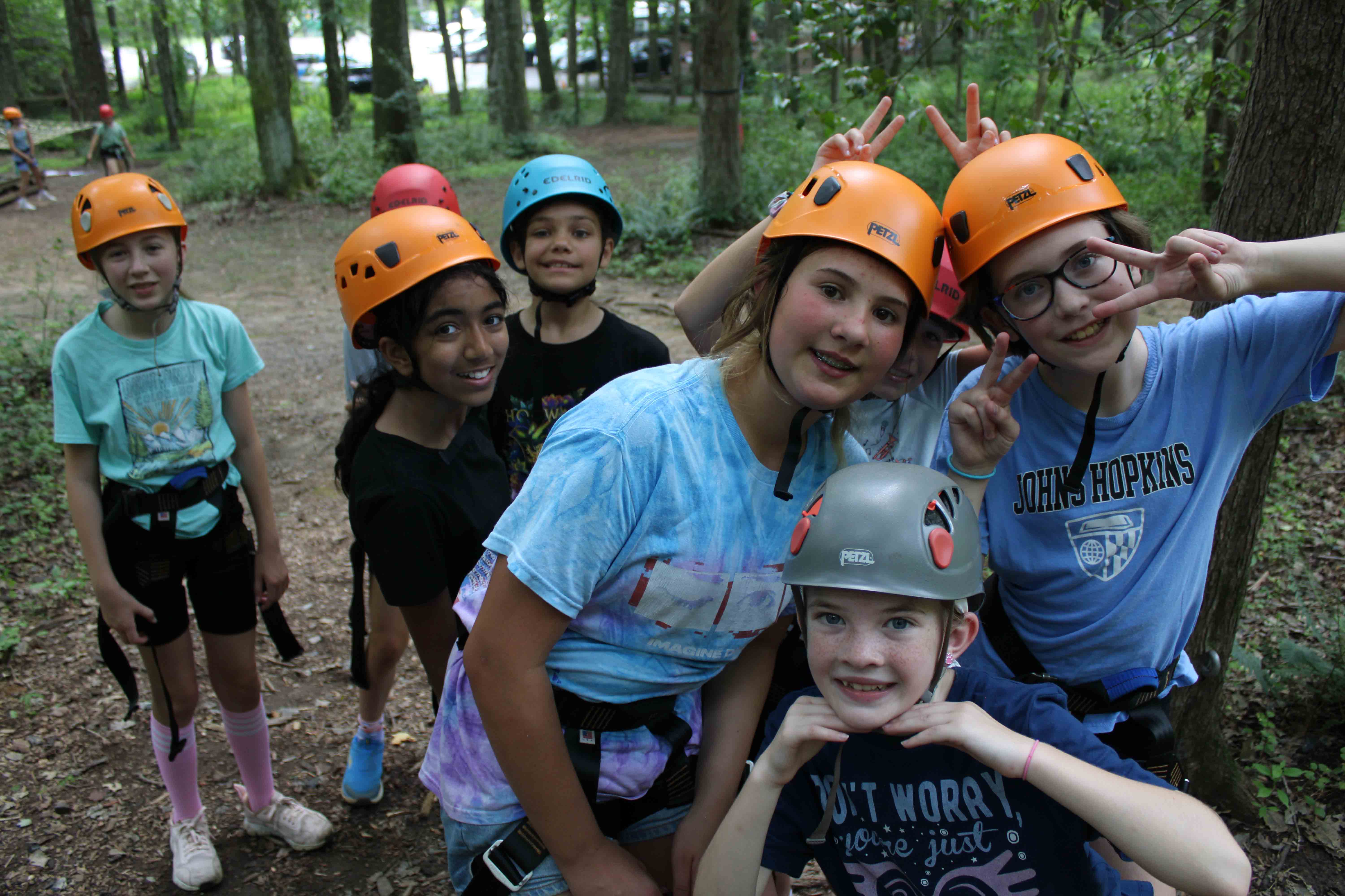 Tornadoes 2 campers wearing safety helmets and preparing for challenge course activities.